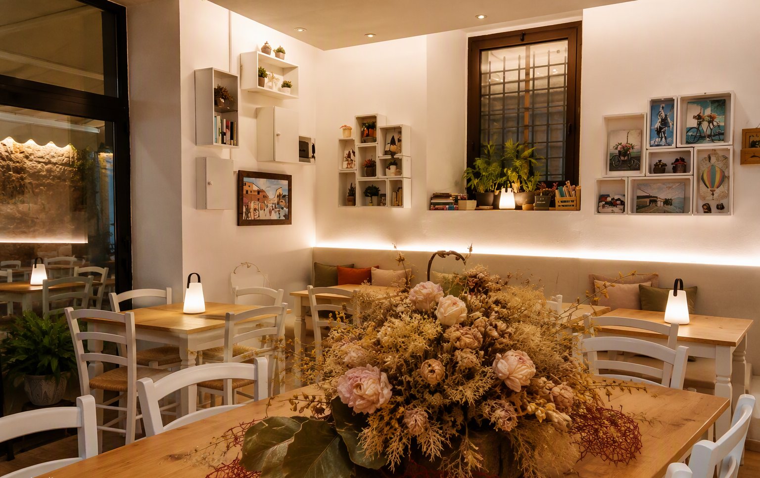 La sala chiara con le sedie bianche e il centrotavola di fiori secchi